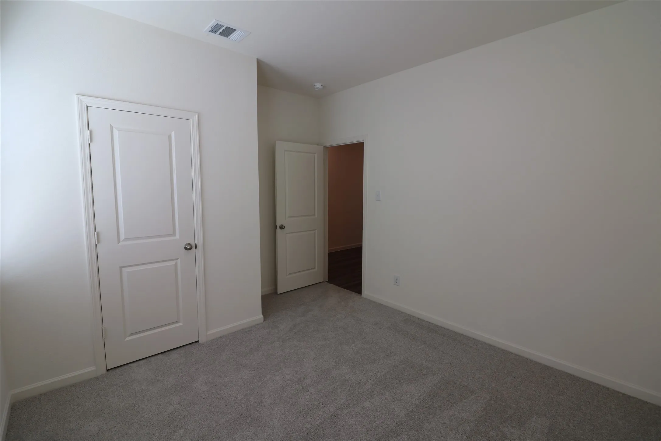 Plush gray carpeting with two-panel interior doors, light neutral wall finishes, and recessed lighting