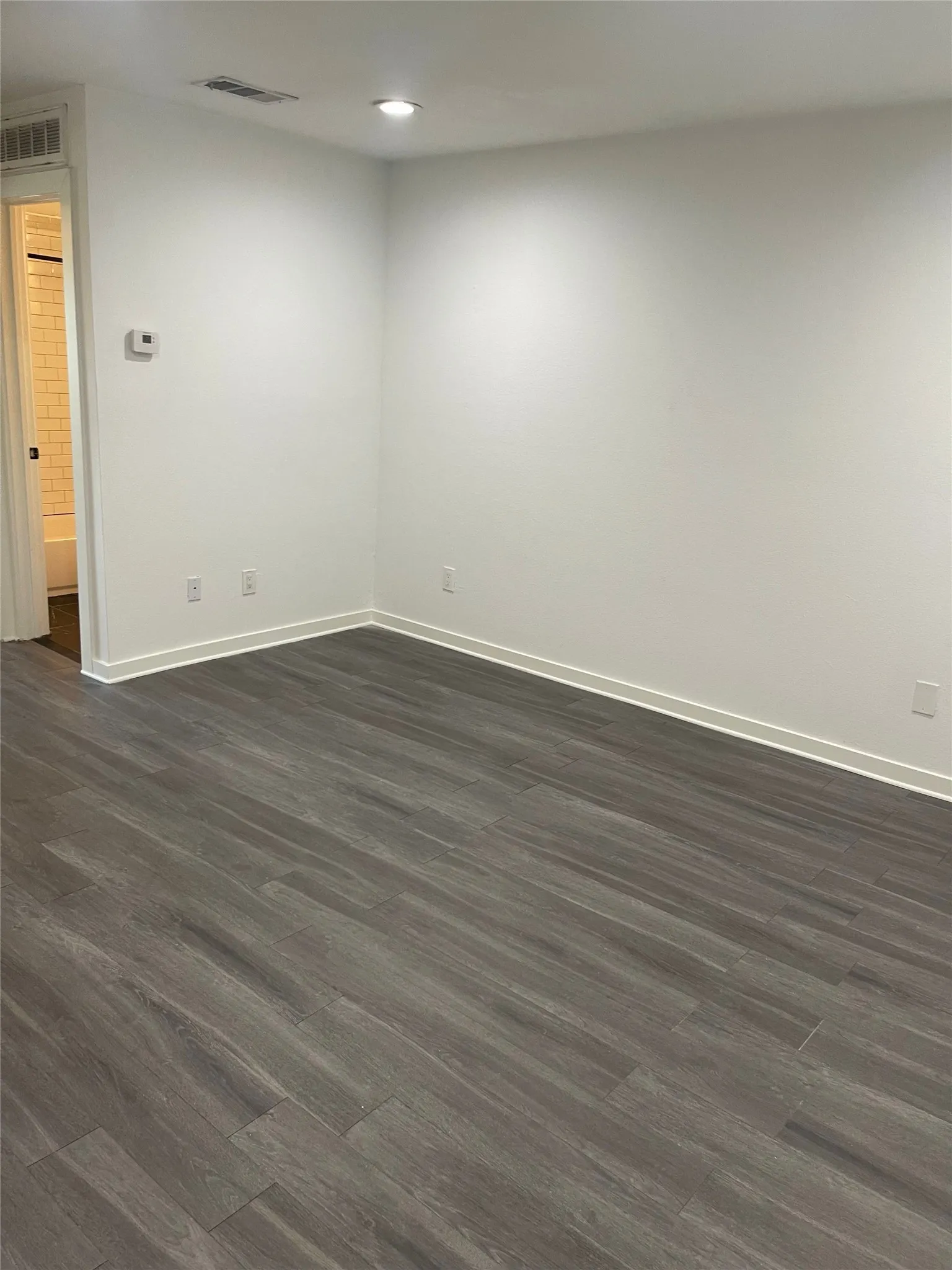 Wood-finish flooring, recessed lighting, and crisp white walls
