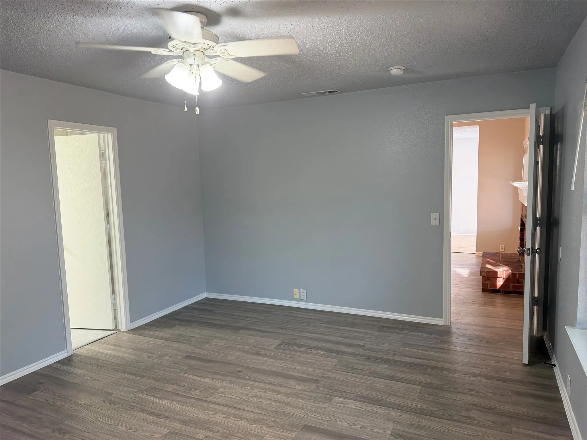 Wood-finish flooring with light gray walls and white trim