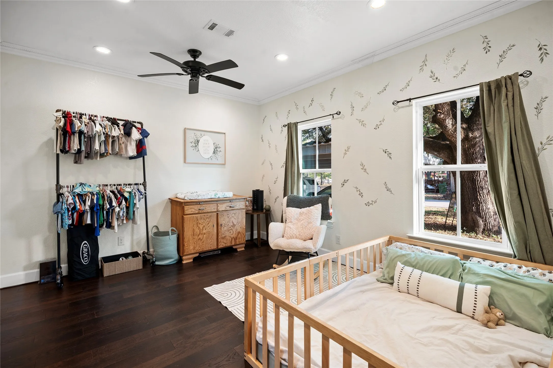 Recessed lighting, crown molding, and dark wood-finish flooring