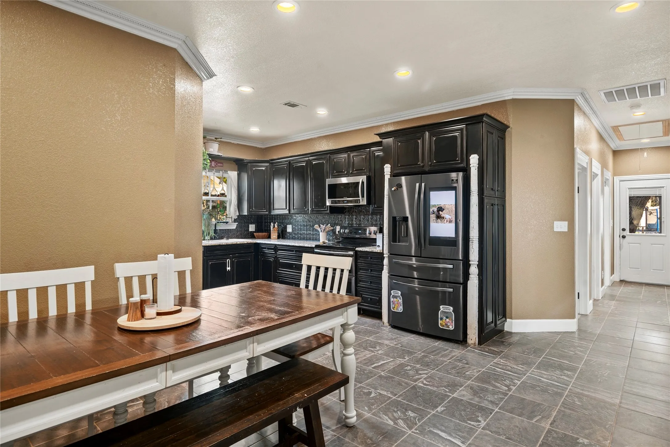 Kitchen featuring dark wood cabinetry, stainless steel appliances, and a subway tile backsplash