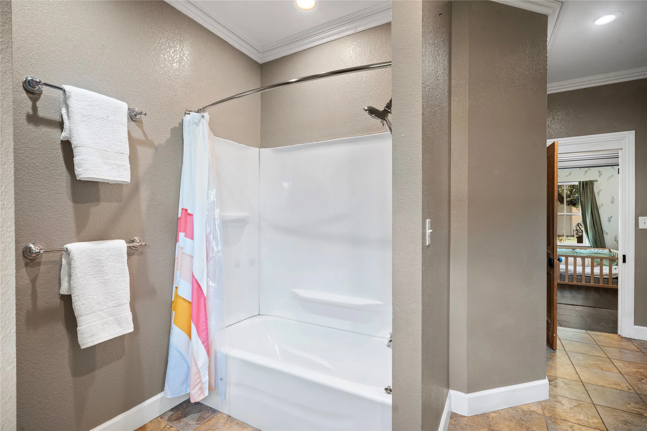Tub and shower combination with white surround, recessed lighting, and tile flooring