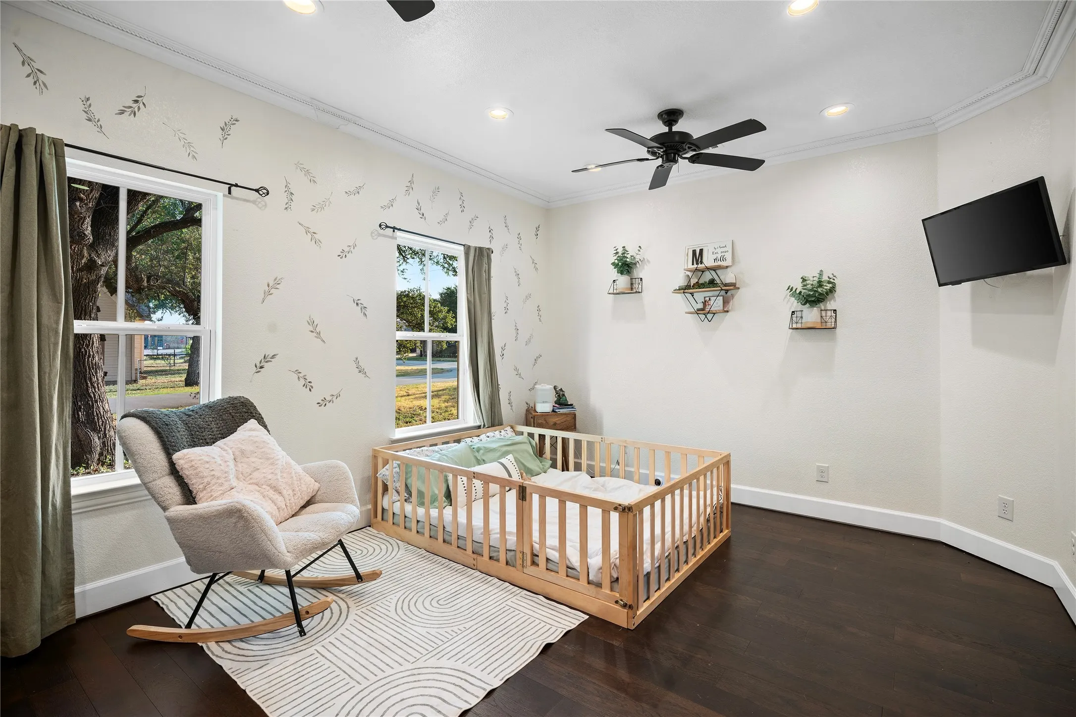 Recessed lighting, crown molding, dark wood-finish flooring, two large windows, and a ceiling fan