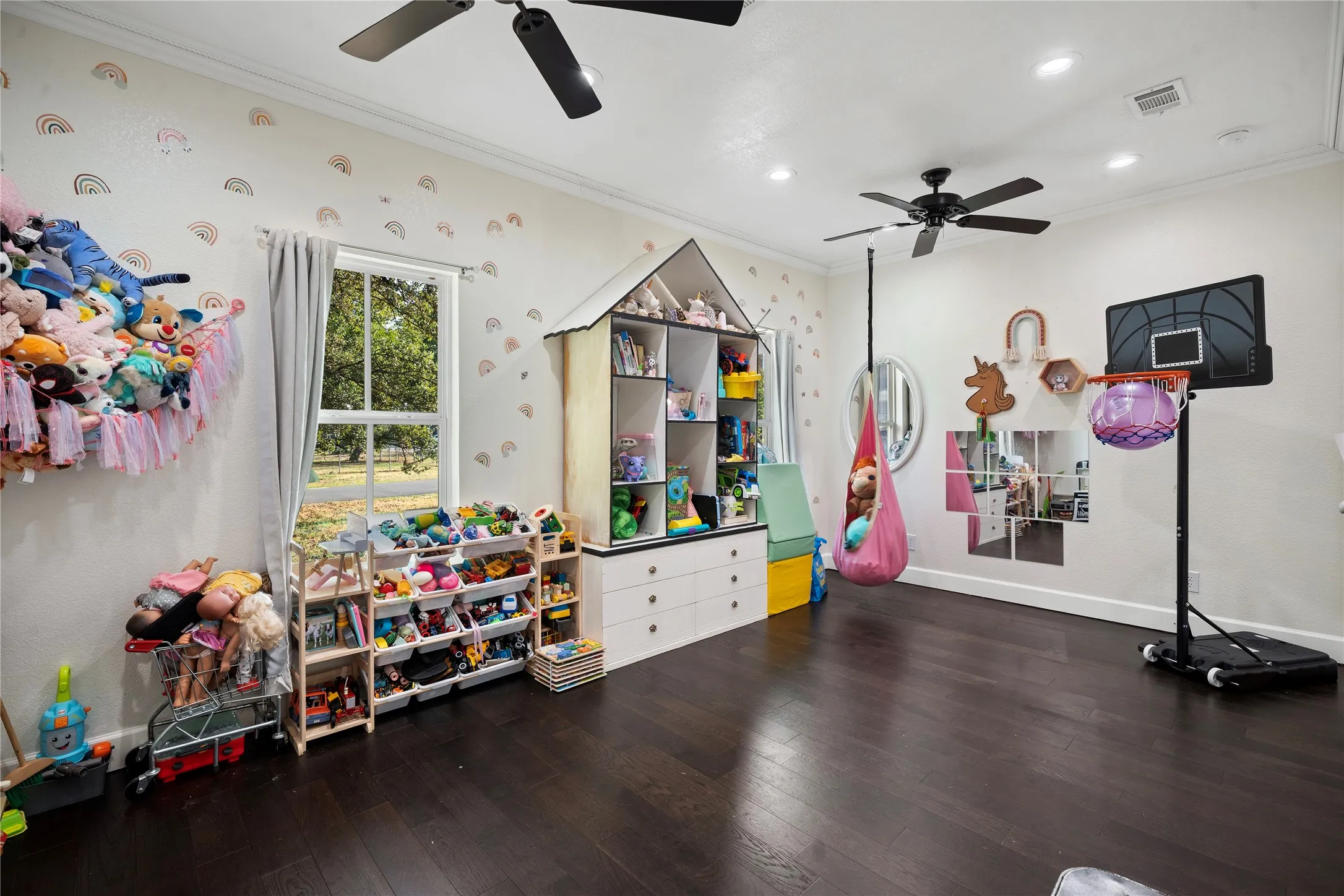 Expansive room featuring dark wood-finish flooring, recessed lighting, and dual ceiling fans