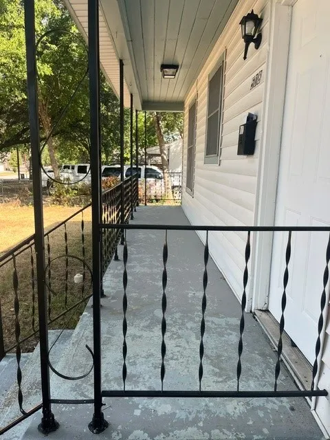 Covered porch with decorative wrought iron railings