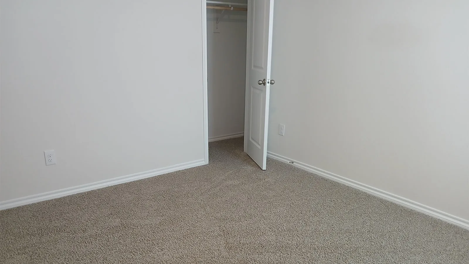 Carpeted flooring, white walls, and a closet with shelving