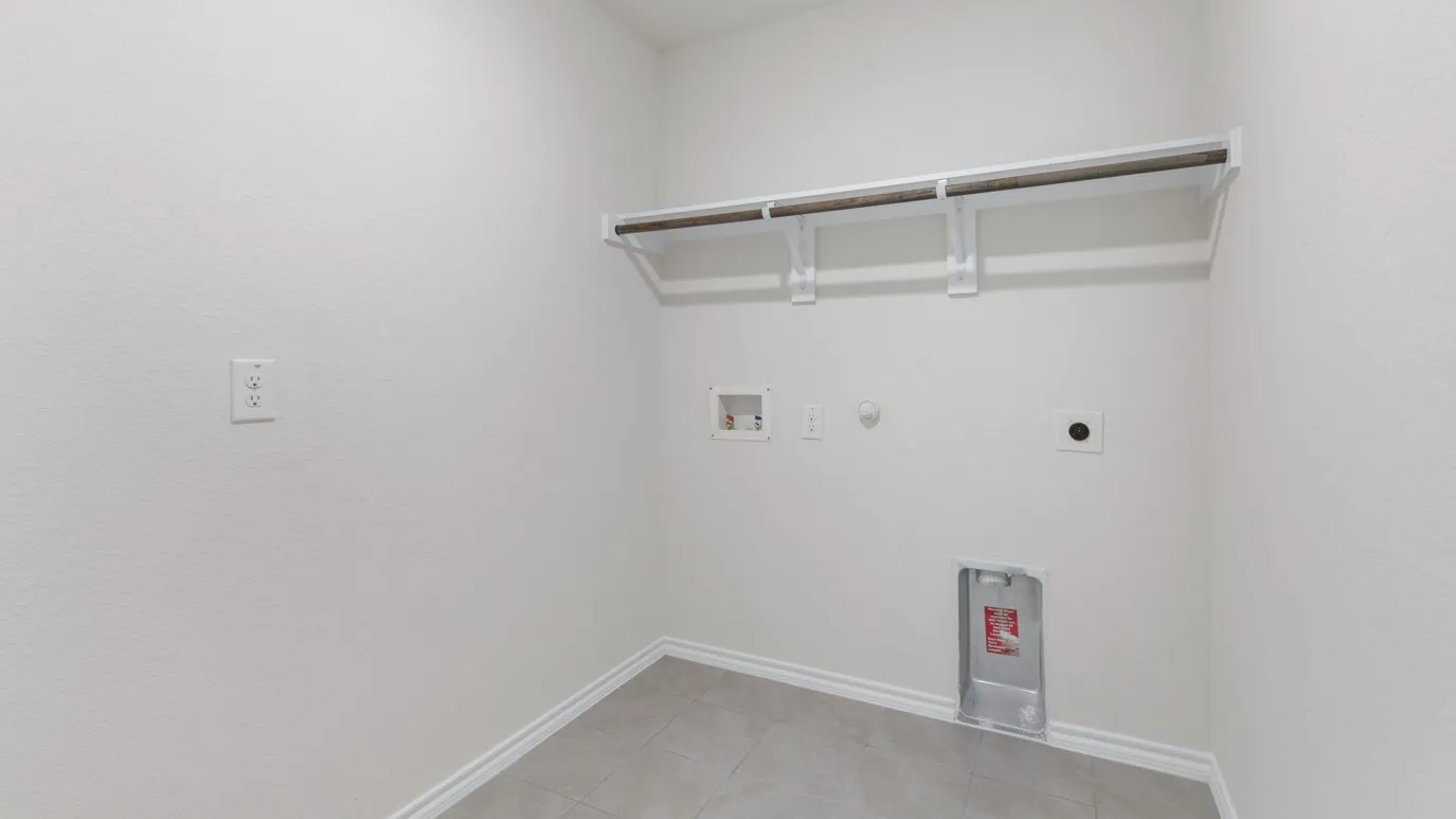 Utility room with tiled flooring and a wall-mounted shelving and hanging rod system