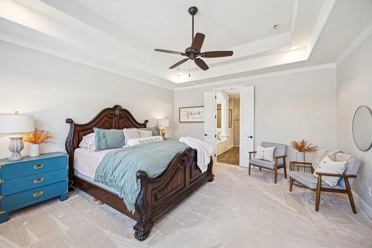 Tray ceiling with crown molding, ceiling fan, and recessed lighting