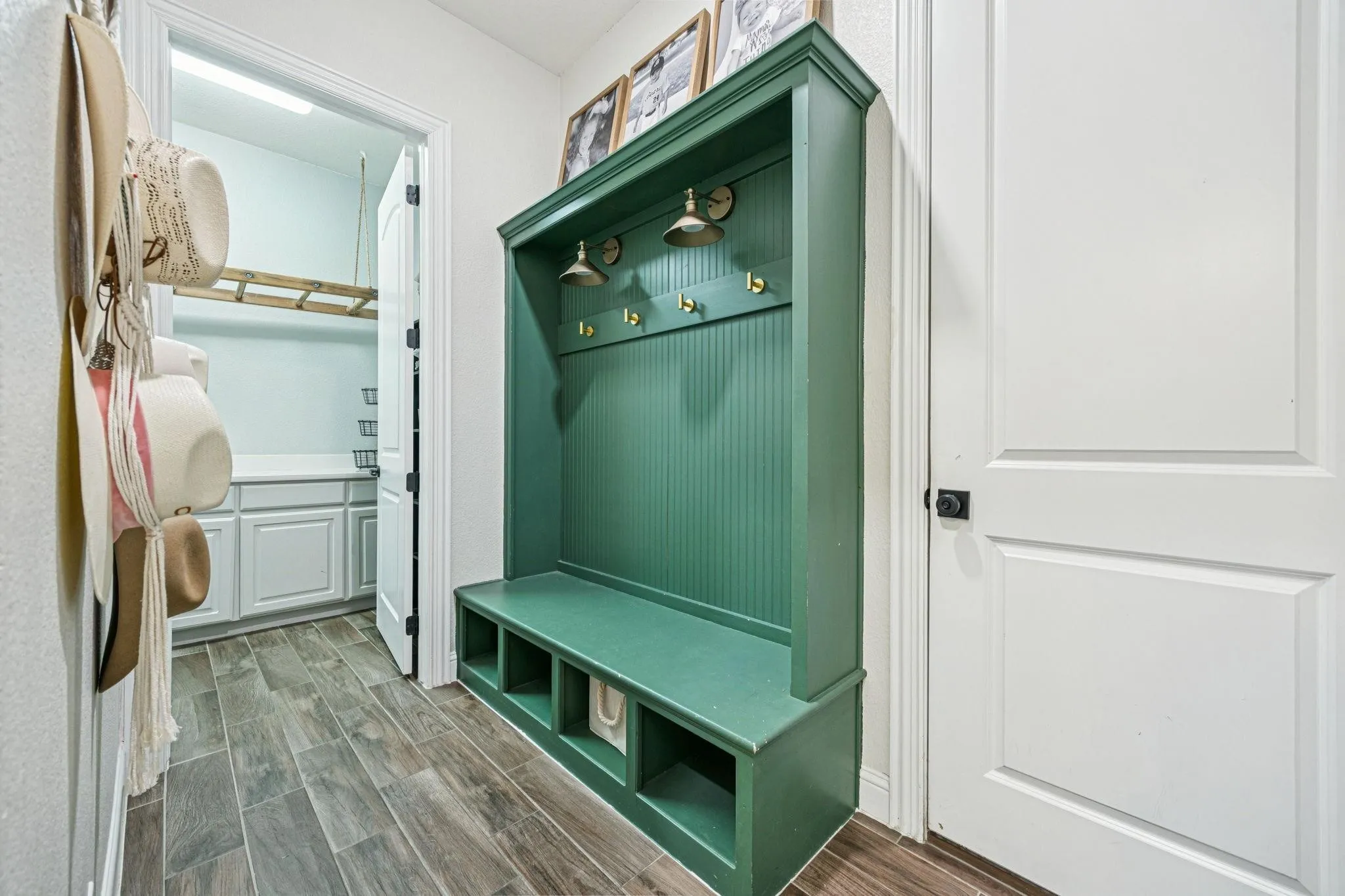 Built-in hall tree with bench seating, integrated storage cubbies, and overhead lighting