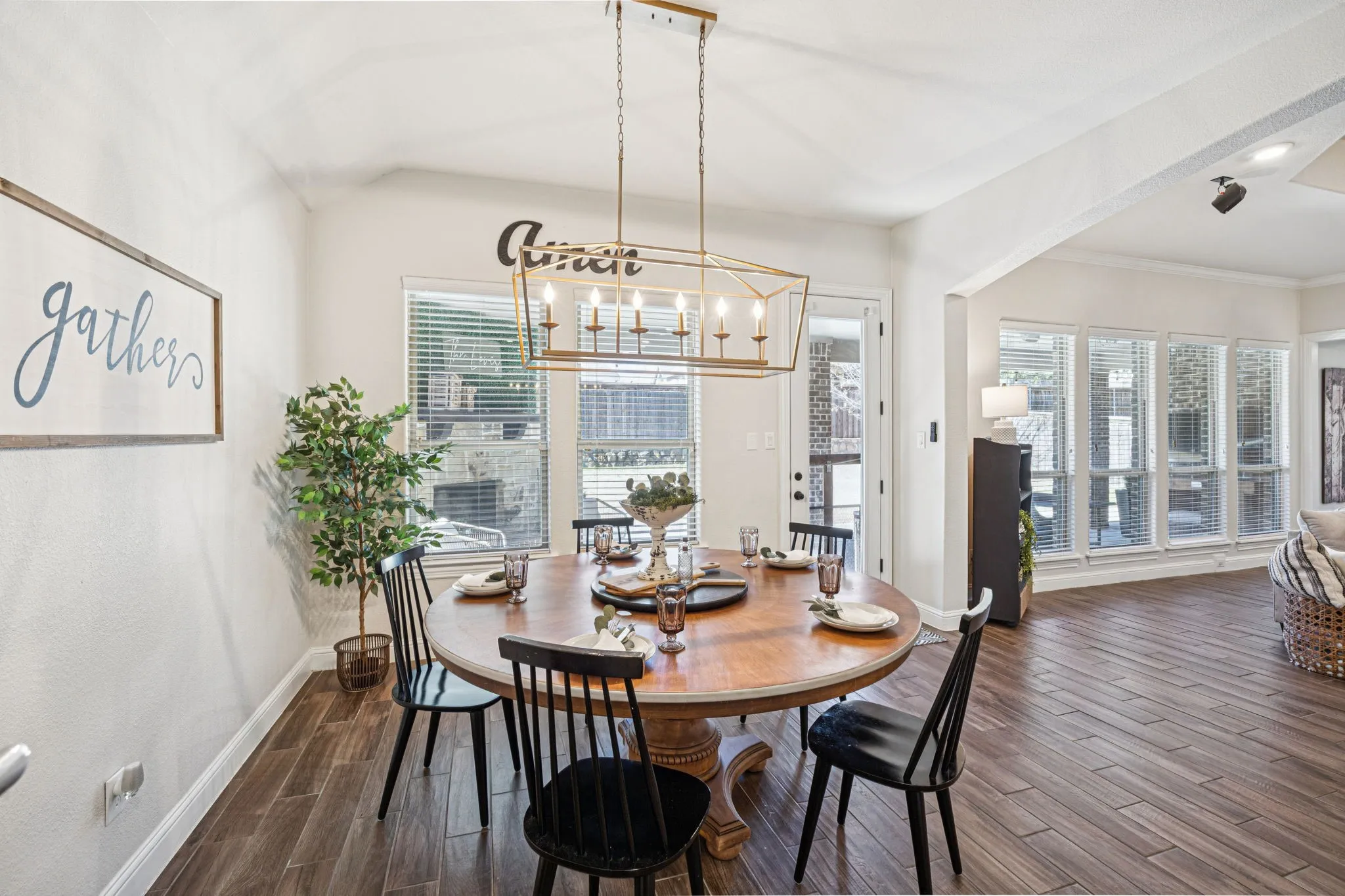 Dining area featuring a geometric chandelier, multiple windows, and wood-finish flooring