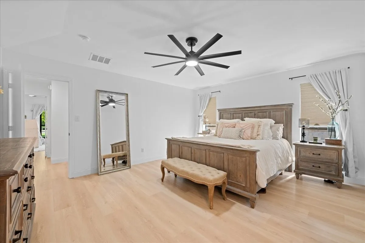 Light wood-finish flooring, vaulted ceiling, recessed lighting, and a modern ceiling fan