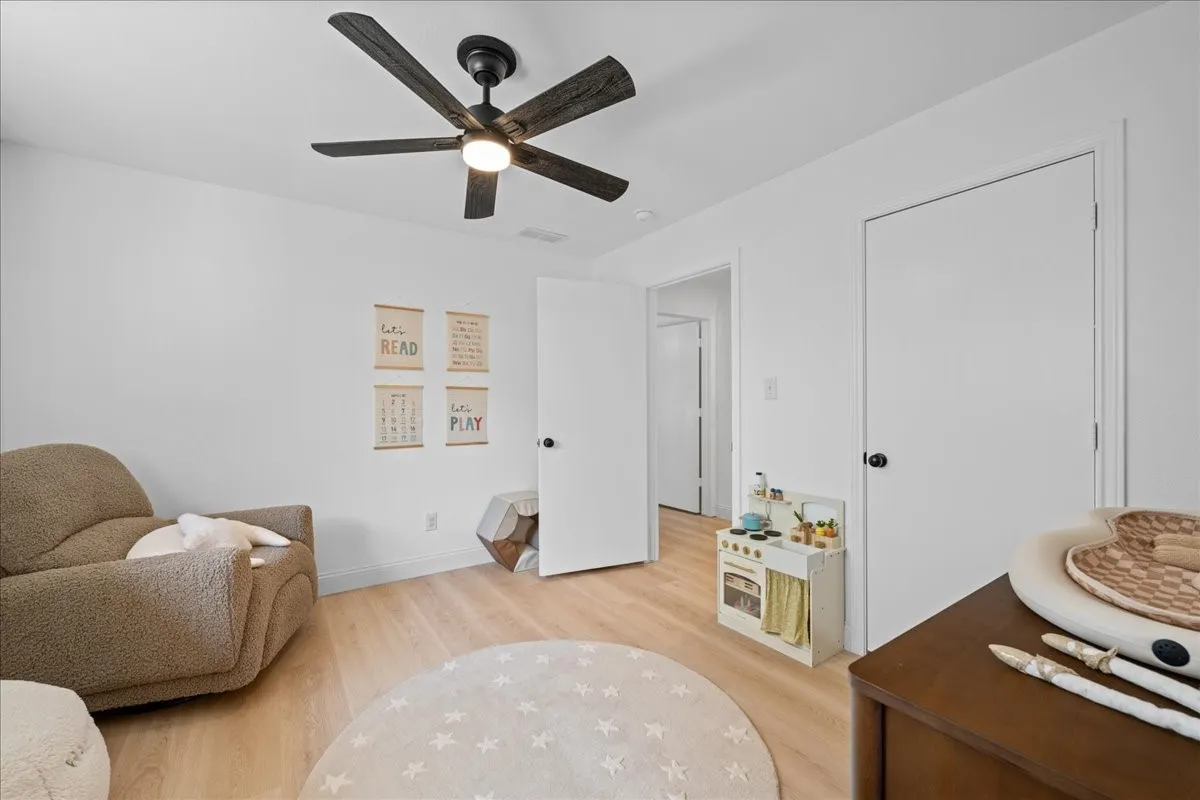 2nd bedroom has recessed lighting, wood-finish flooring, ceiling fan with integrated lighting, white walls, and white trim