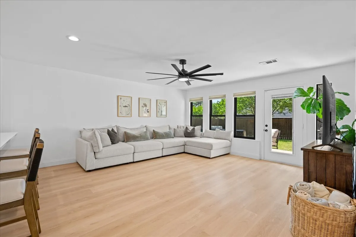 Open-concept living space featuring wood-finish flooring, recessed lighting, and a modern ceiling fan