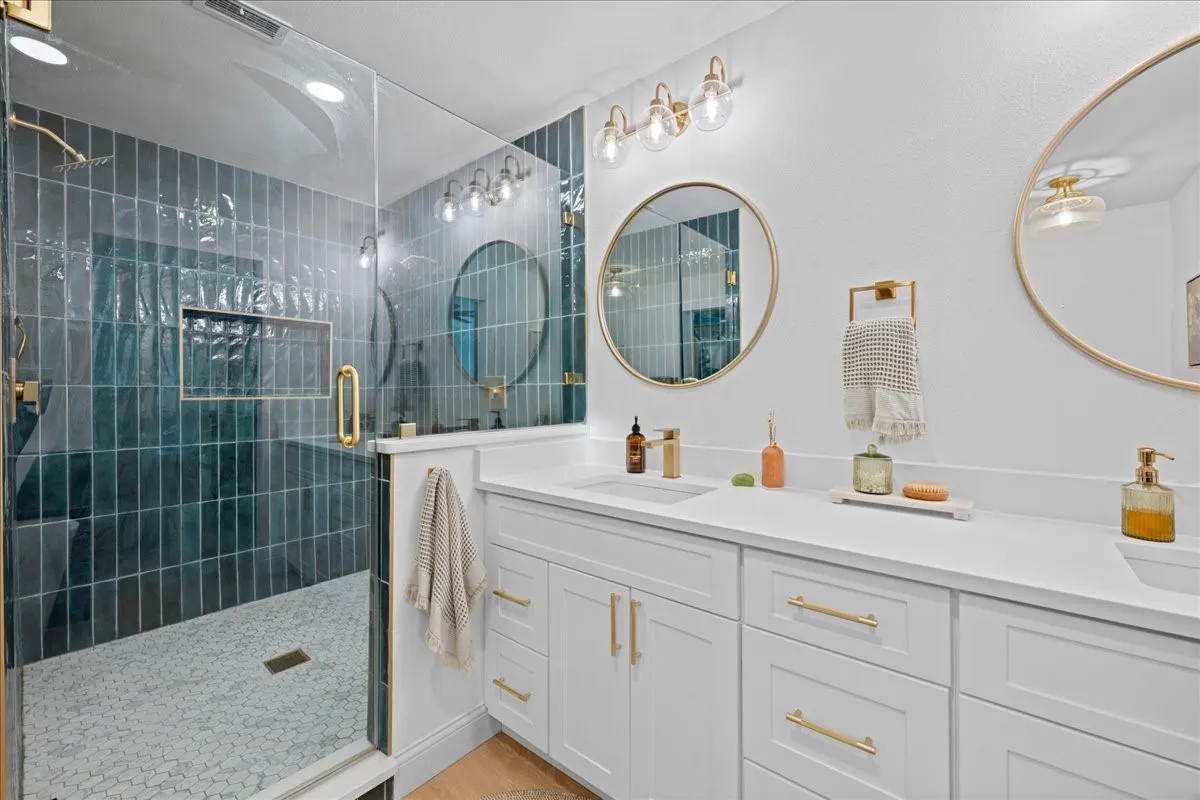 Dual vanity with white cabinetry, gold-tone hardware, and integrated sinks