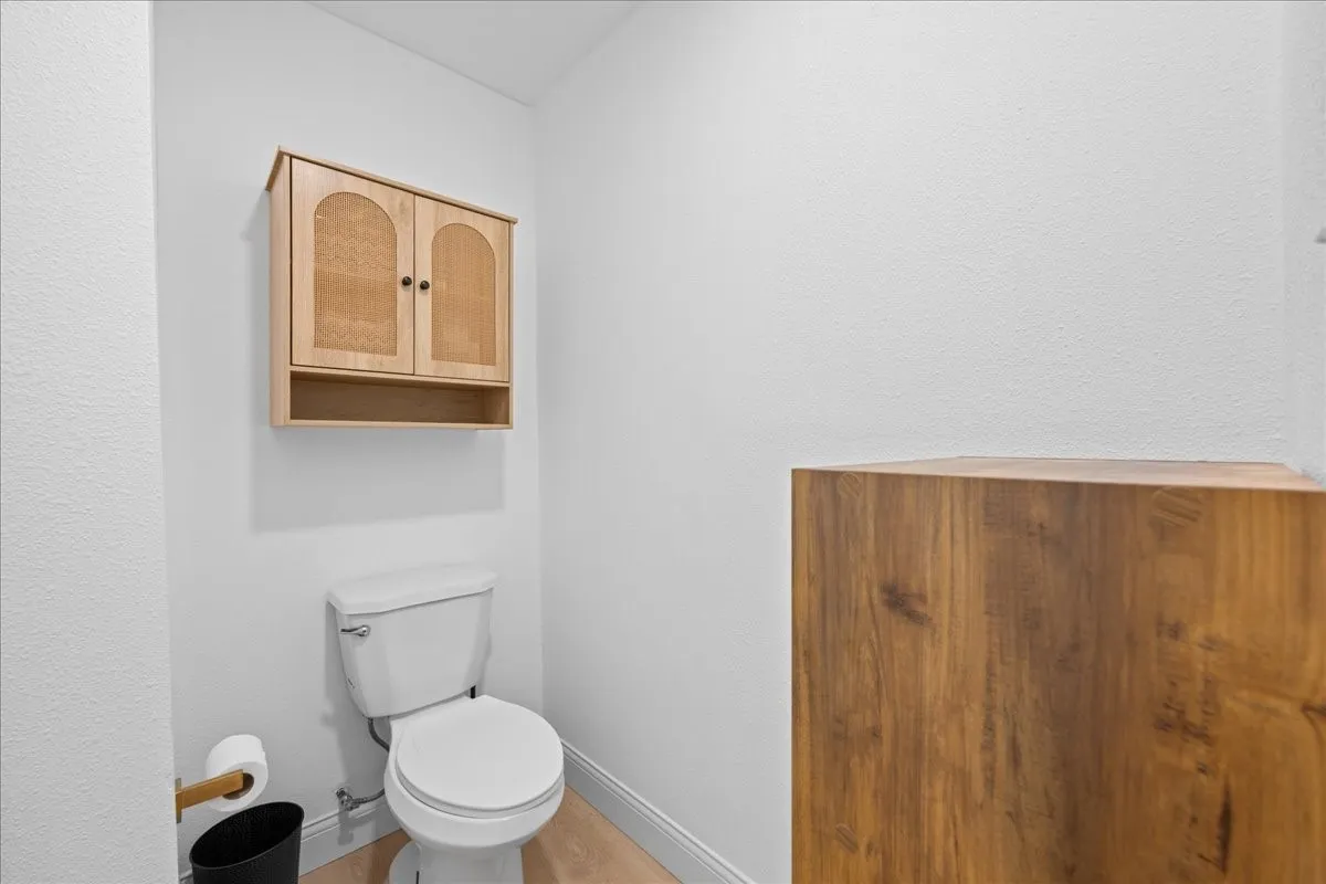 Wall-mounted wood-finish cabinet with arched panel doors