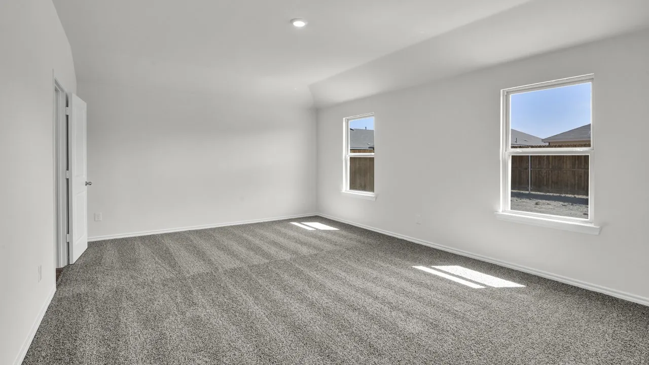 Spacious room featuring neutral carpeting, white walls, two windows, and a recessed ceiling light