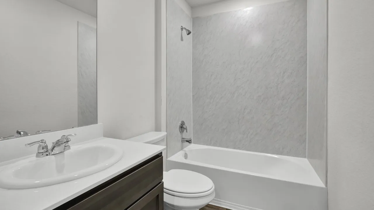 White vanity with a single basin sink, chrome faucet, and integrated countertop