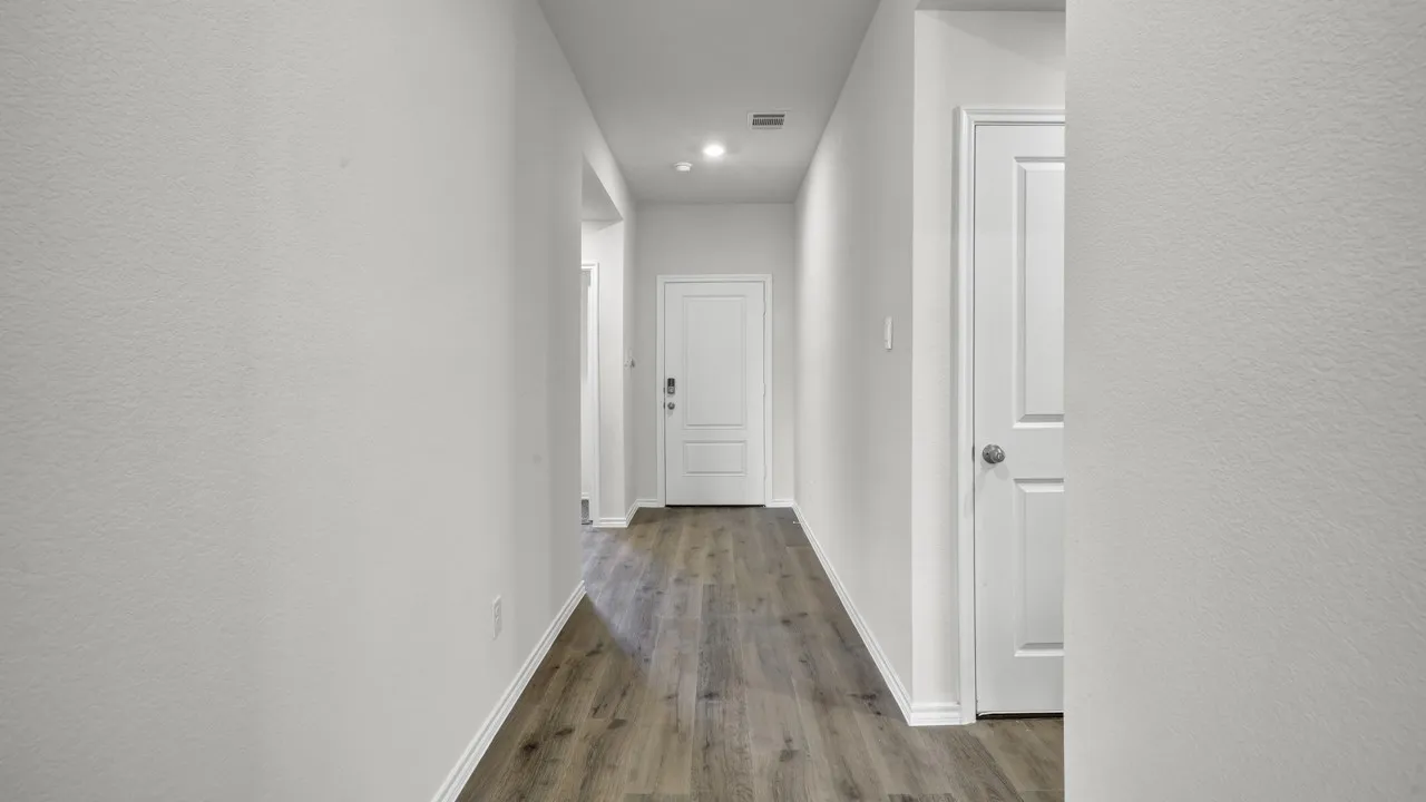 Hallway featuring wood-finish flooring, recessed lighting, and white paneled doors