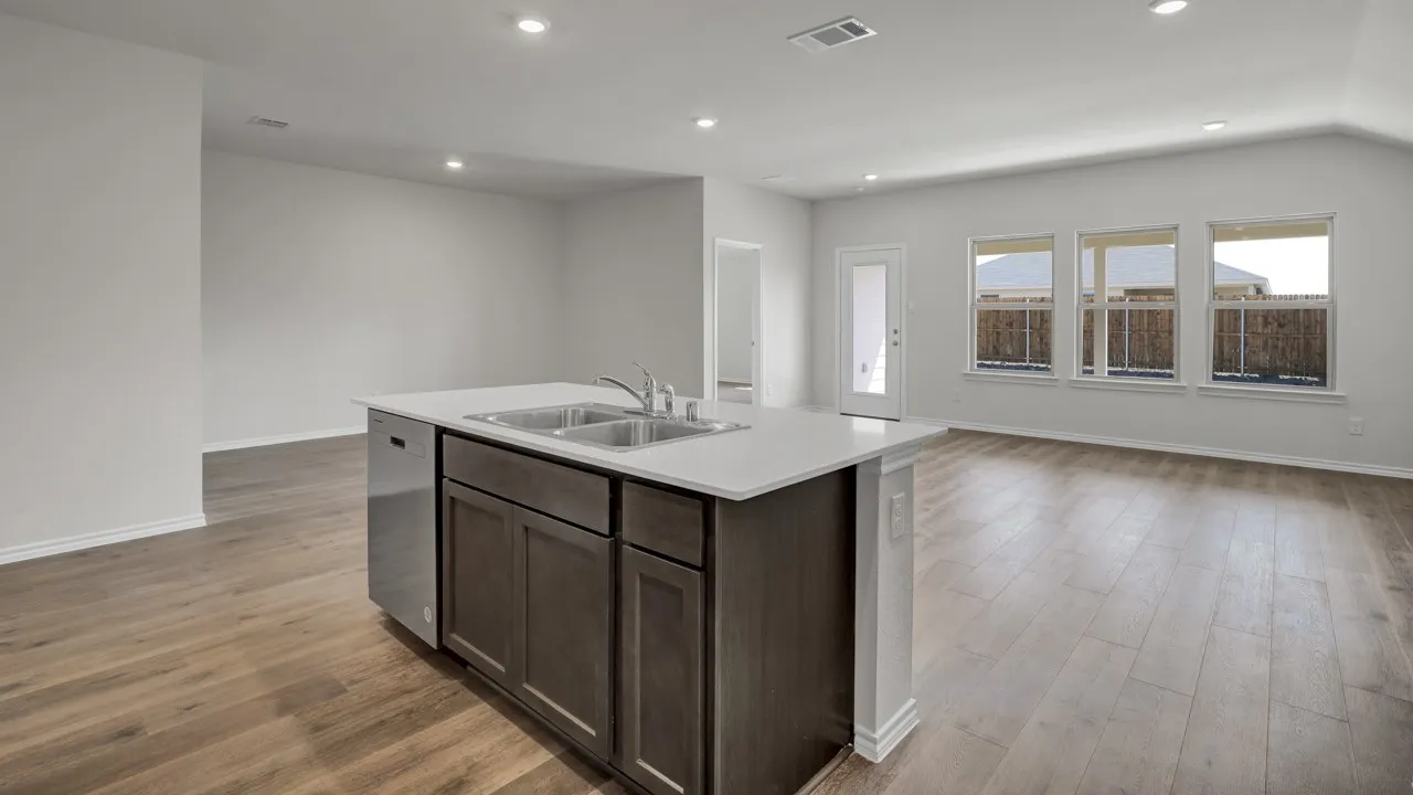 Kitchen island with a double basin sink, stainless steel dishwasher, and built-in cabinetry
