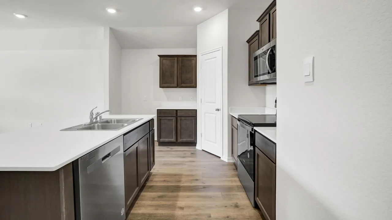 Kitchen featuring a stainless steel double sink, white countertops, built-in microwave, and wood-finish flooring