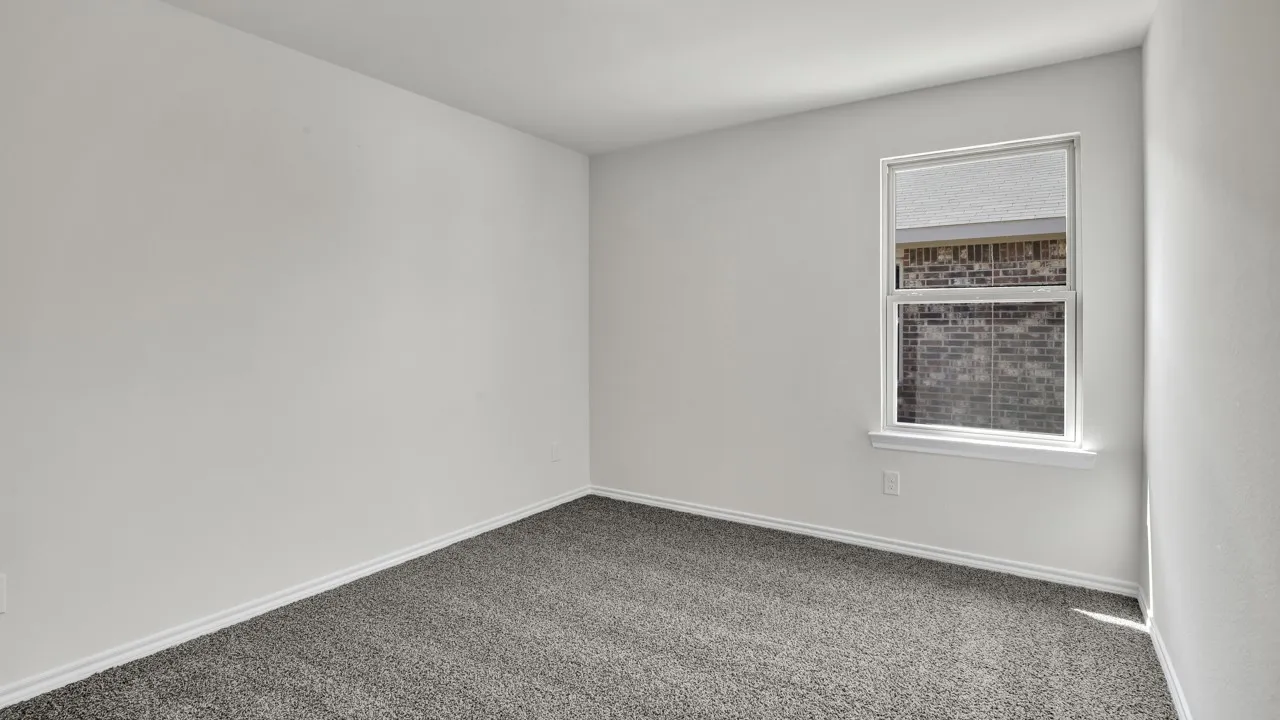 Neutral paint palette with a single window and gray carpet flooring