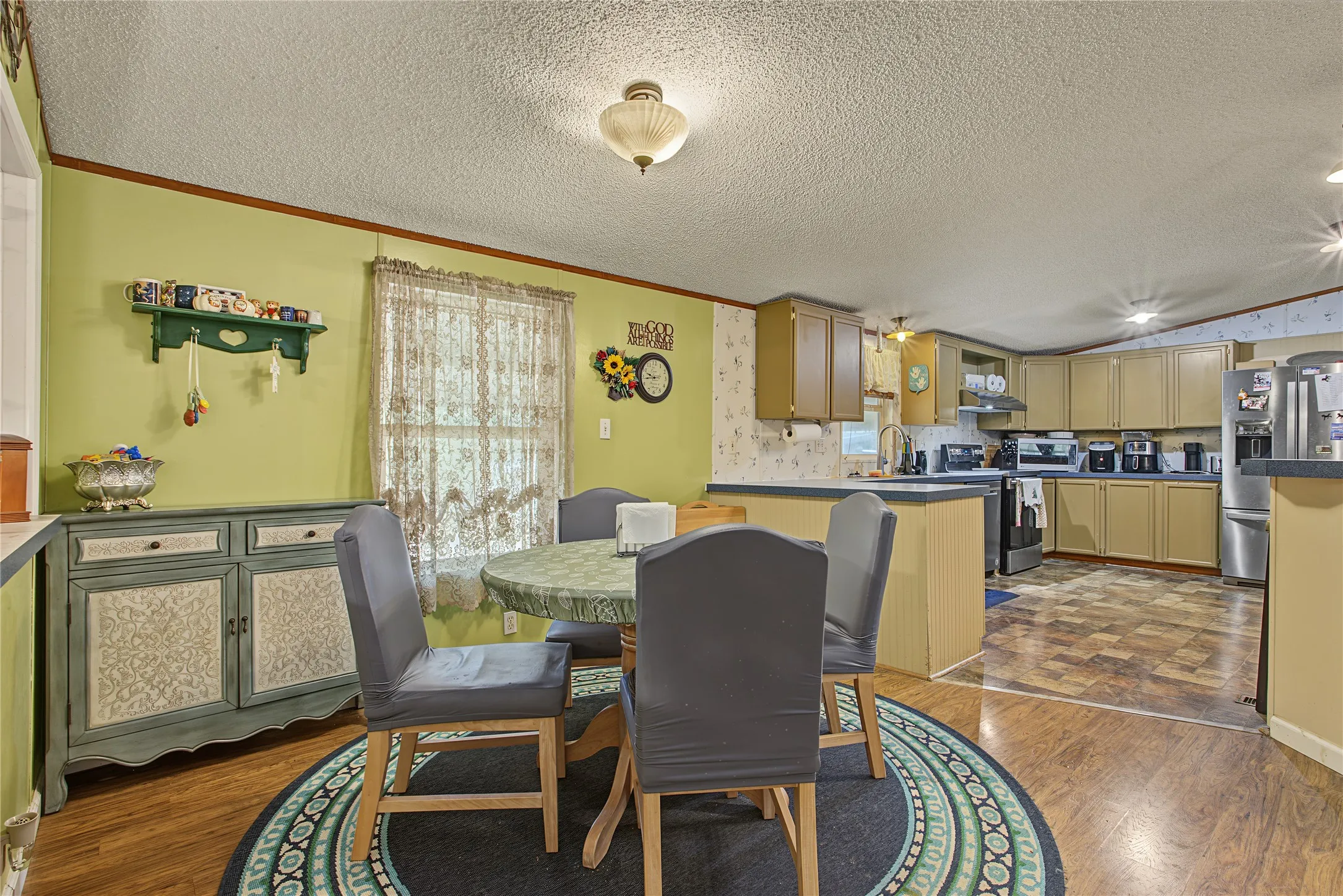 Kitchen area with wood-finish flooring, wood cabinetry, and stainless steel appliances