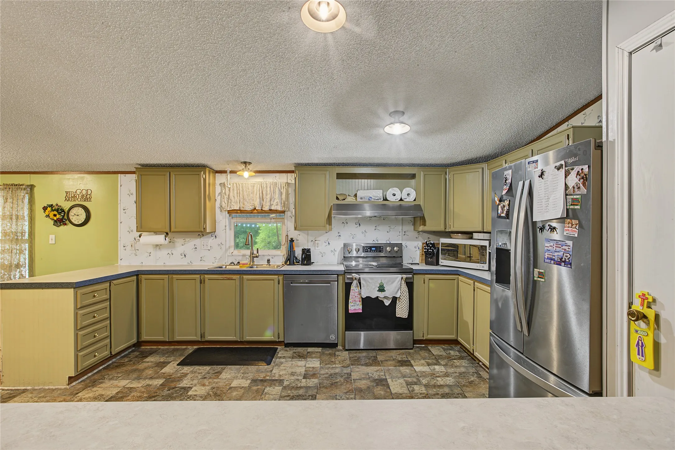 Kitchen featuring ample cabinetry, stainless steel appliances, a double basin sink, and mosaic-style flooring