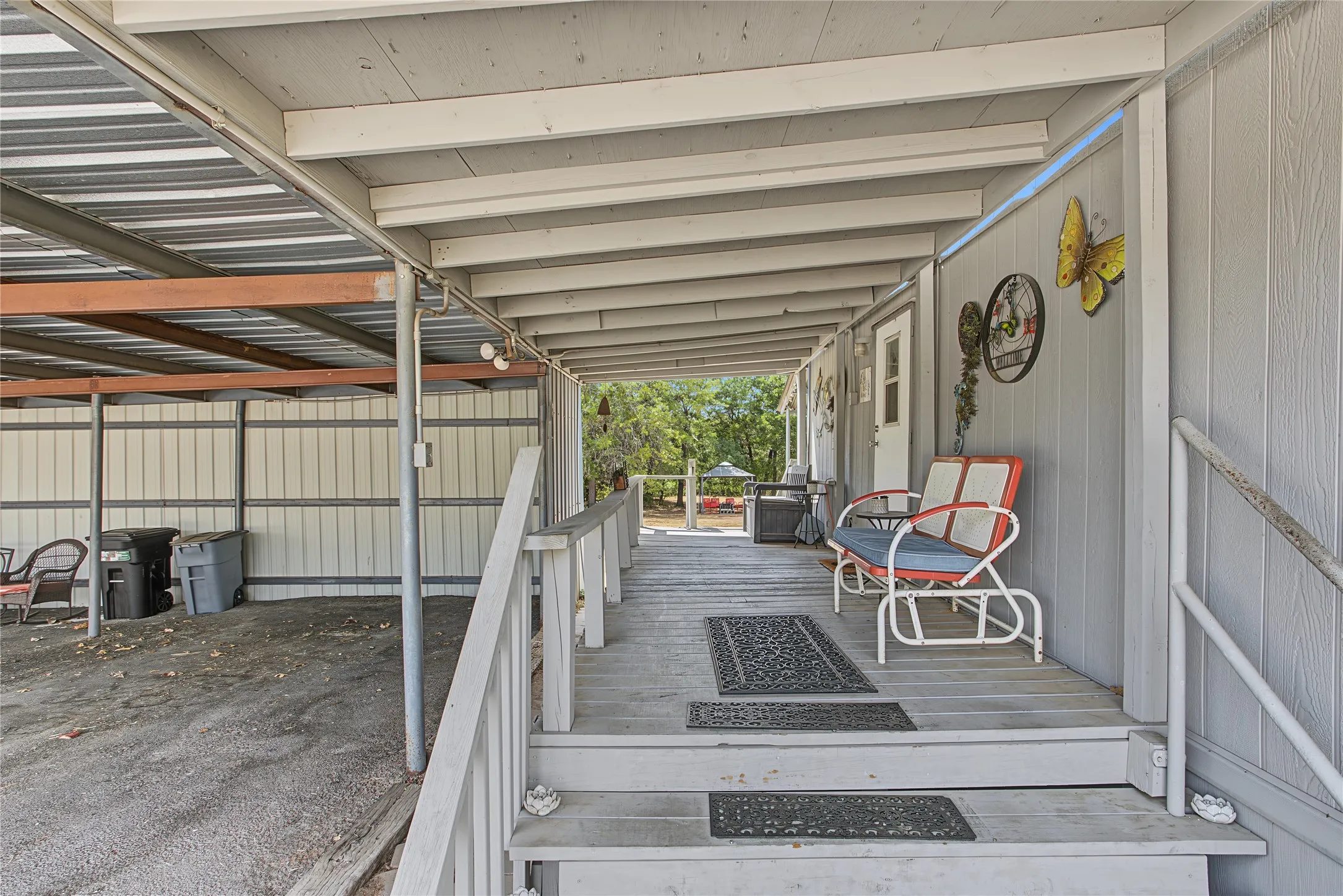 Covered porch with wood flooring and painted railings
