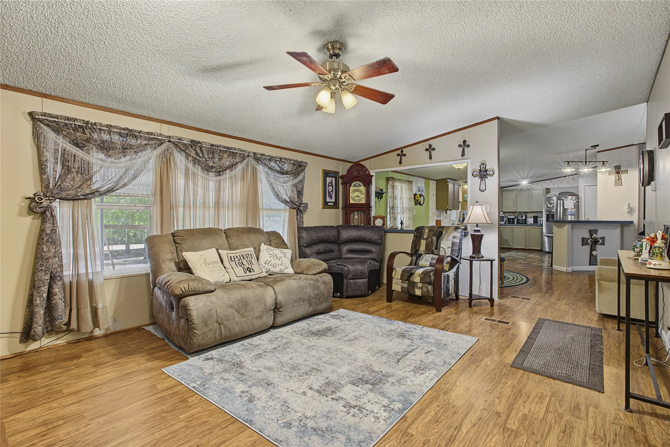 Wood-finish flooring throughout, ceiling fan with integrated lighting, and neutral wall tones