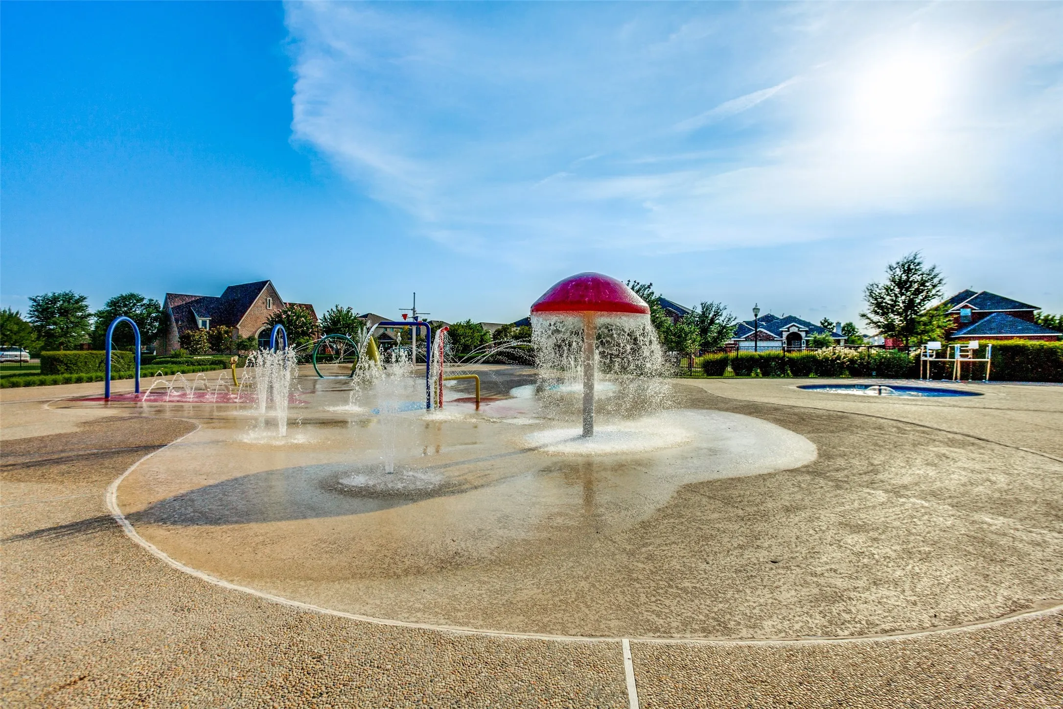 Community splash pad with multiple water features and a textured ground surface