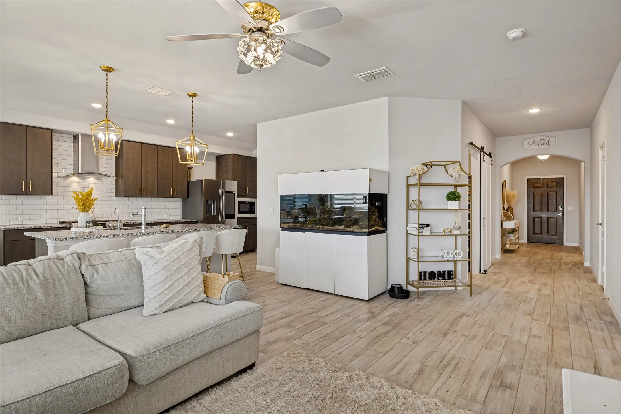 Wood-finish flooring, recessed lighting, and a decorative ceiling fan with an integrated light fixture