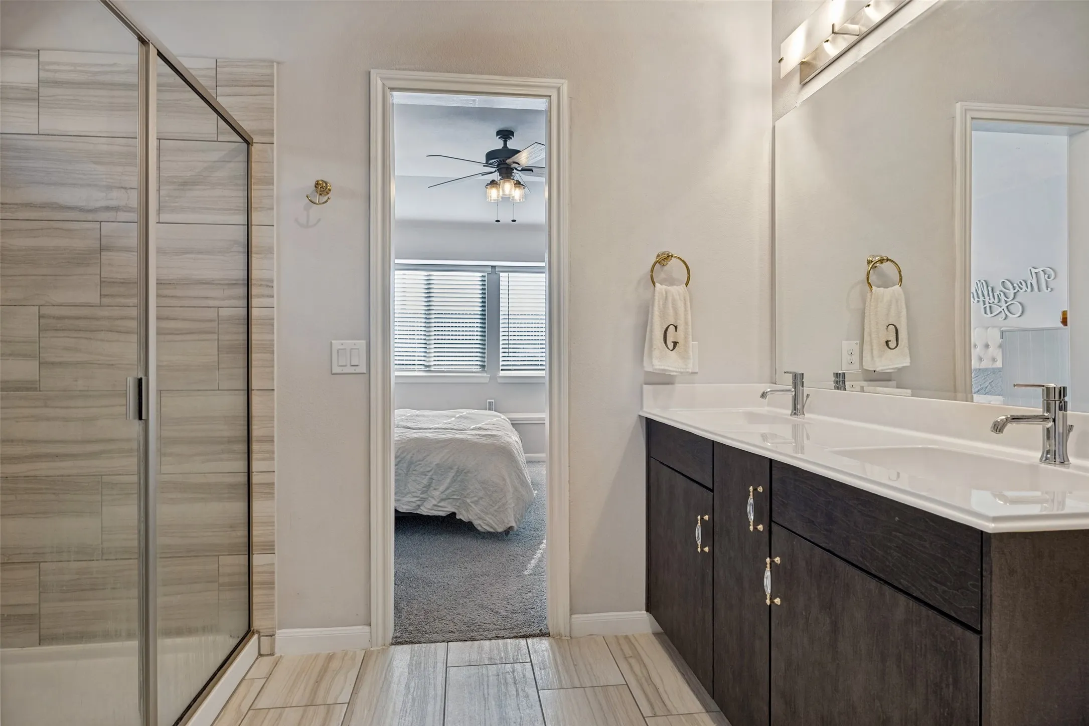 Dual vanity with undermount sinks, contemporary faucets, and dark wood-finish cabinetry
