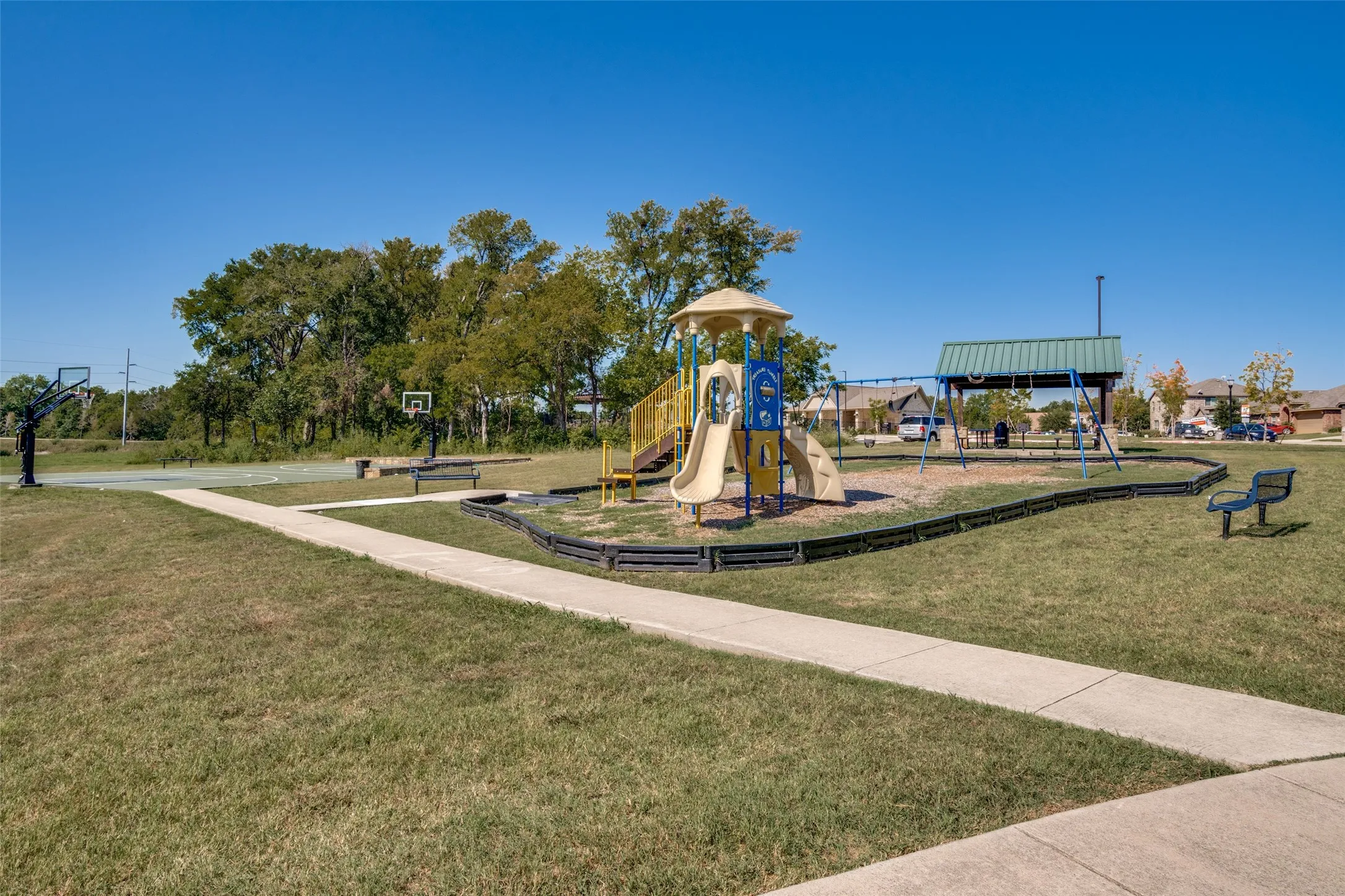 Community playground with multiple slides, swings, and a covered picnic area