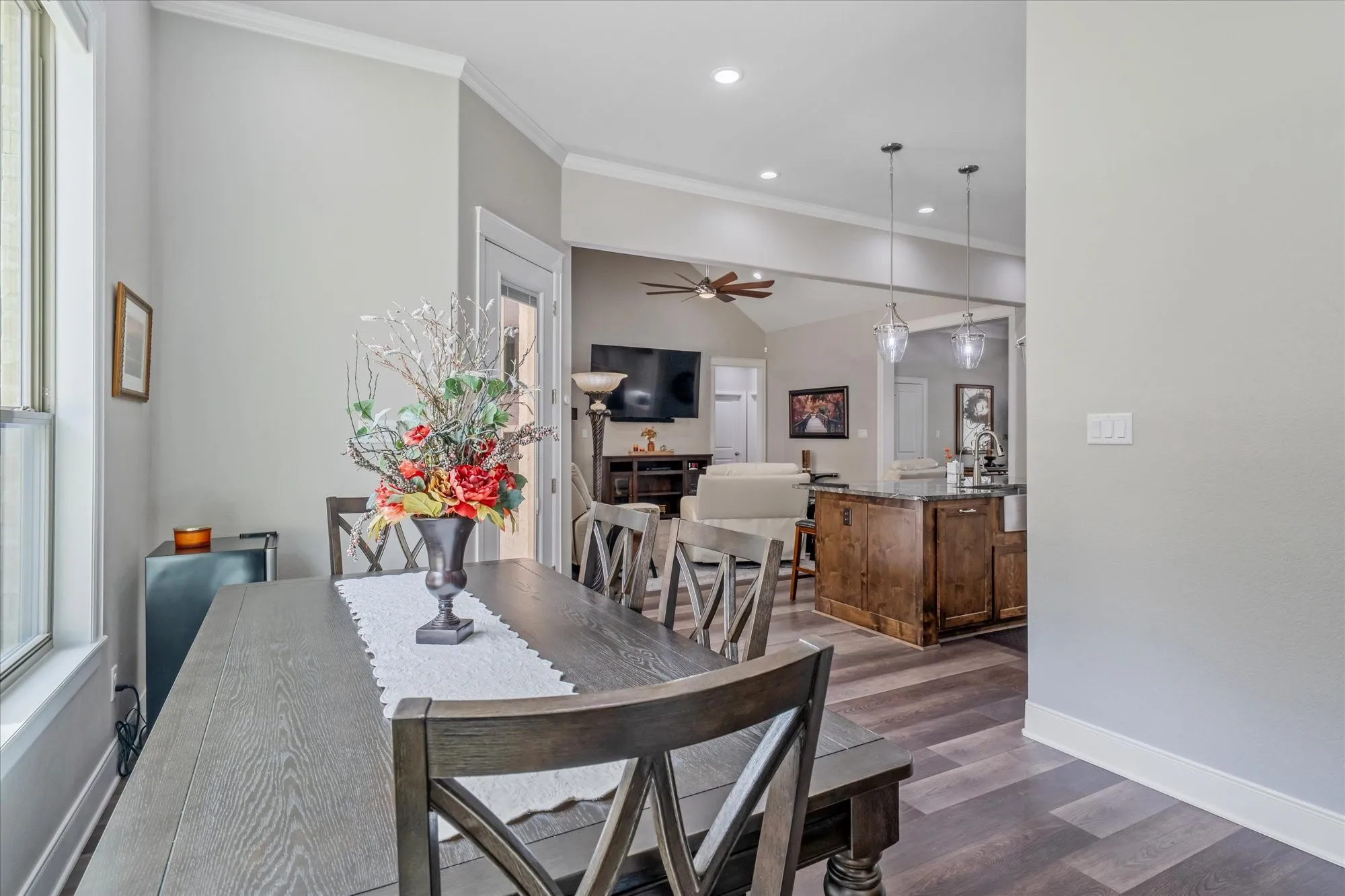 Recessed lighting, wood-finish flooring, vaulted ceilings, and a kitchen island with pendant lighting