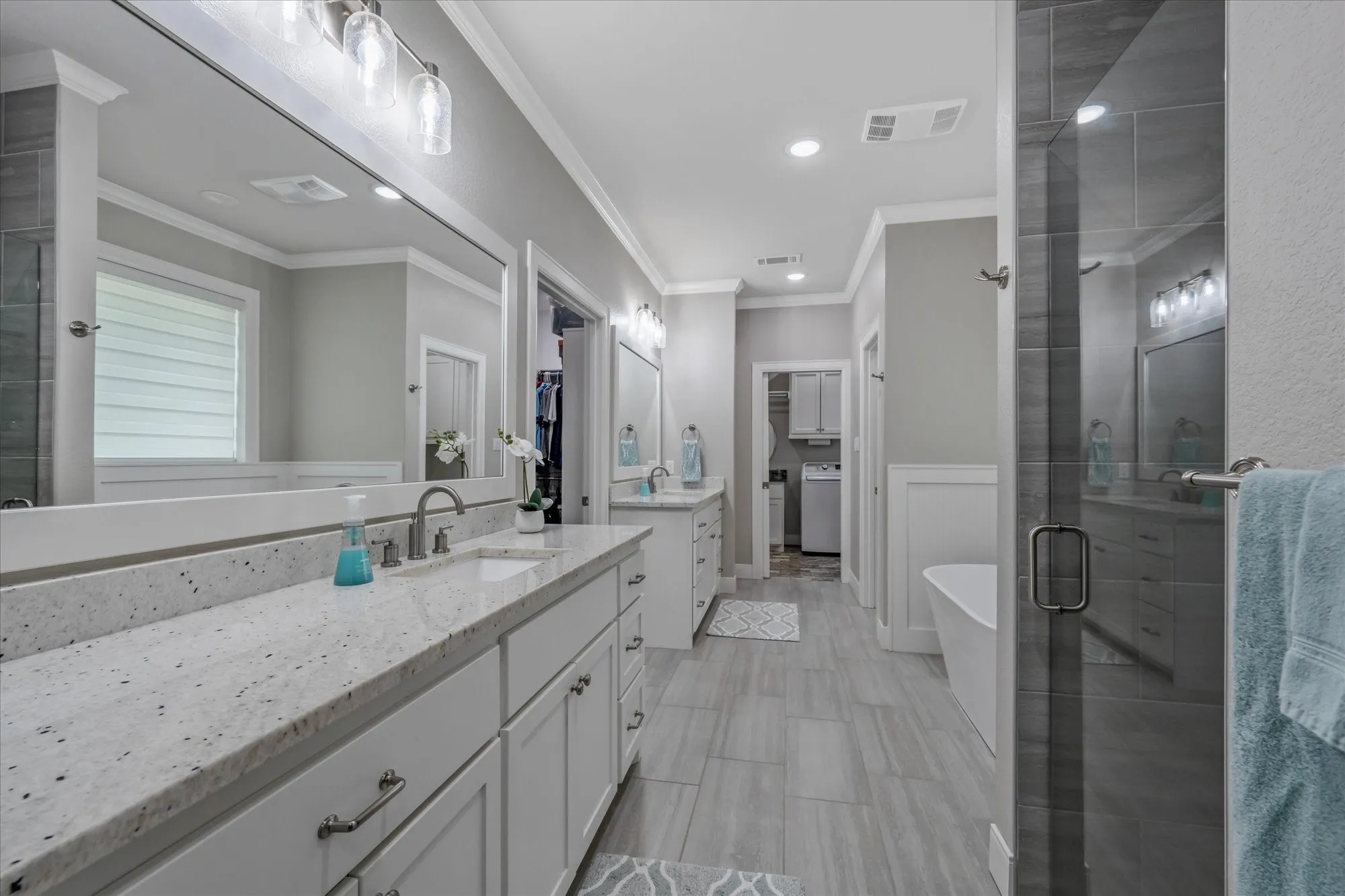 Expansive vanity with a light-toned countertop, dual sinks, and ample storage cabinetry