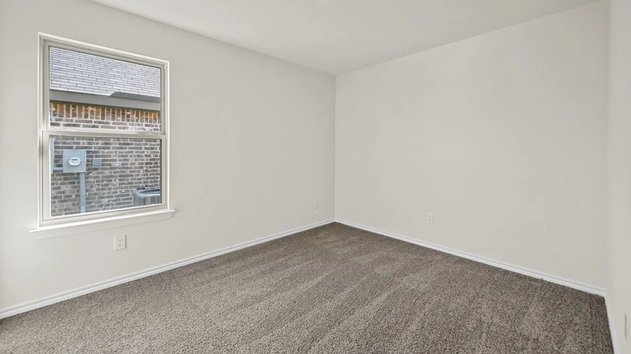 Neutral wall tones, gray carpeting, and a white framed window