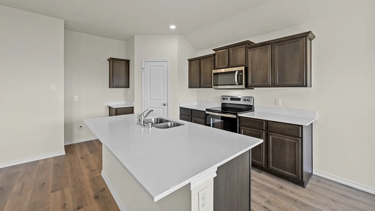 Kitchen featuring wood-finish flooring, dark wood cabinetry, white countertops, and stainless steel appliances