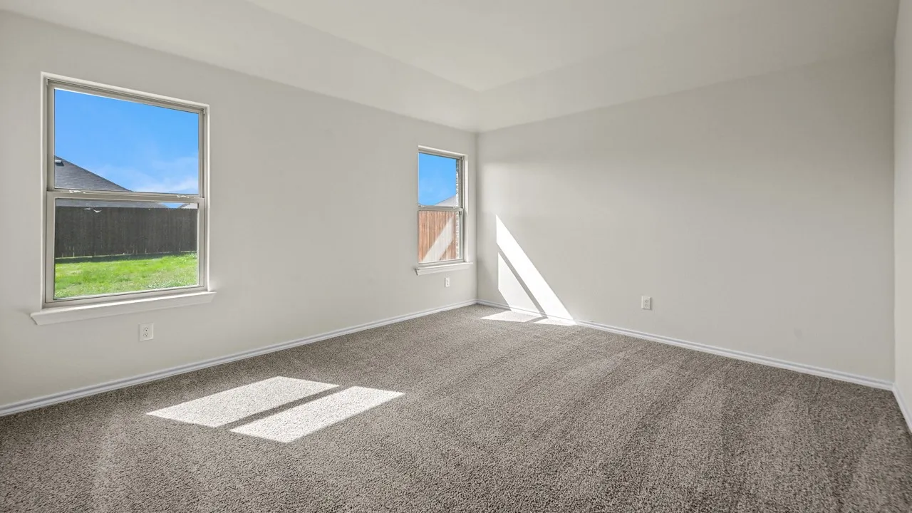 Neutral wall paint, gray carpet flooring, two windows, and a tray ceiling