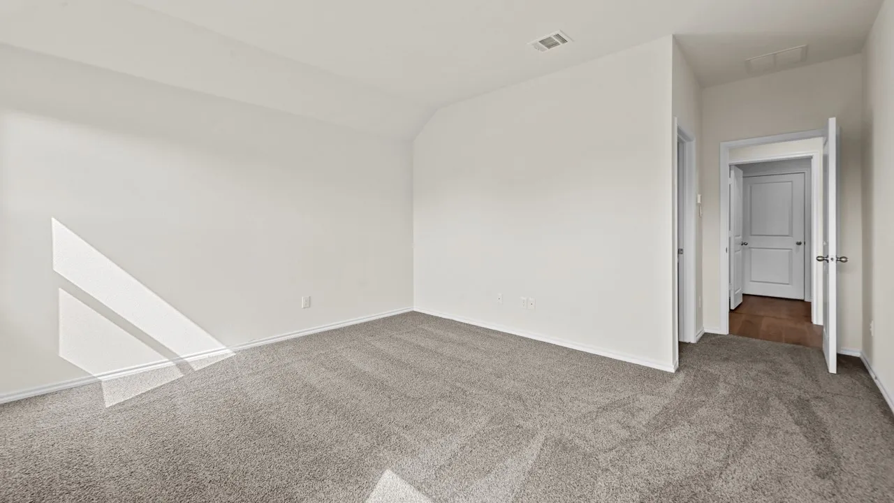 Spacious room with plush gray carpeting, crisp white walls, and a recessed ceiling light