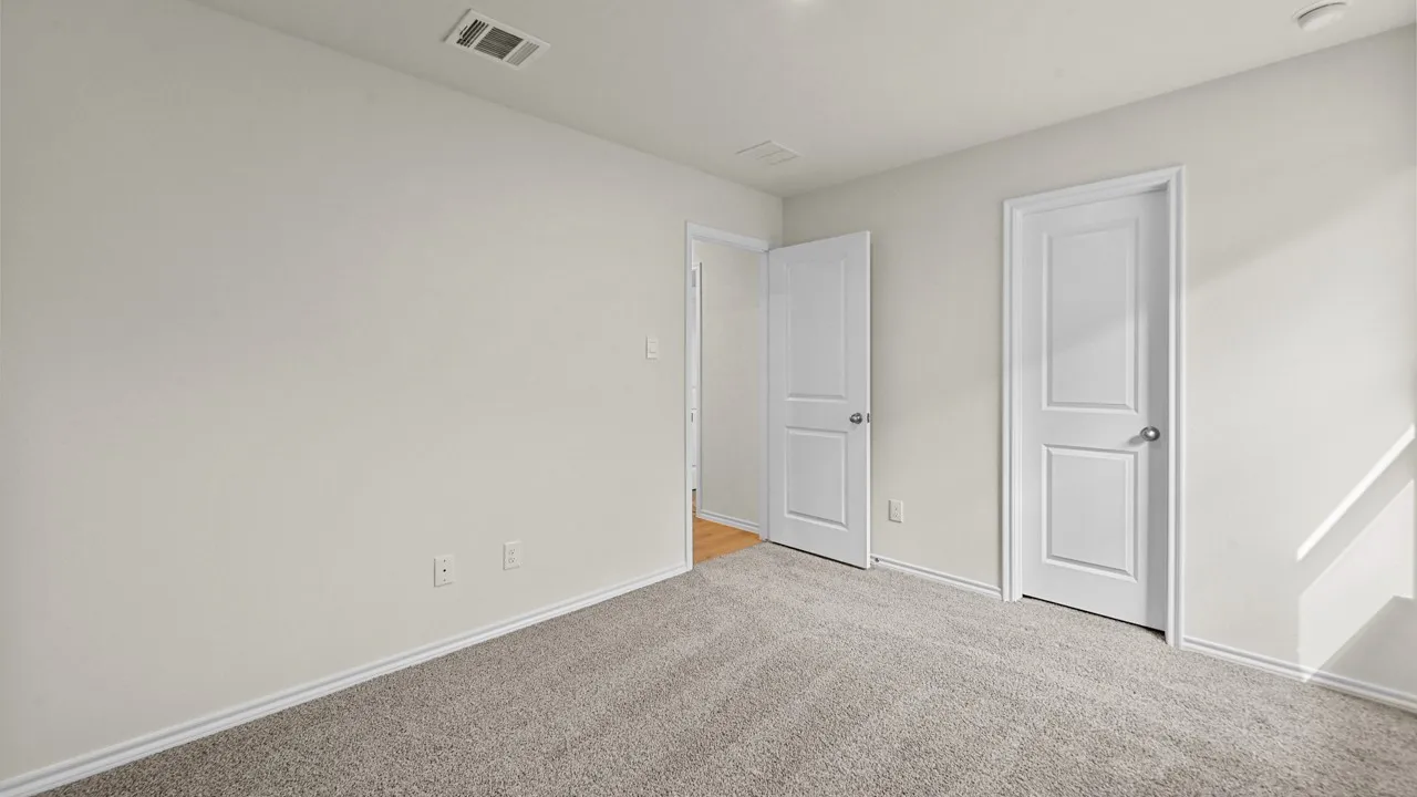Plush carpet flooring, light-toned walls, recessed ceiling lighting, and two panel doors with chrome hardware