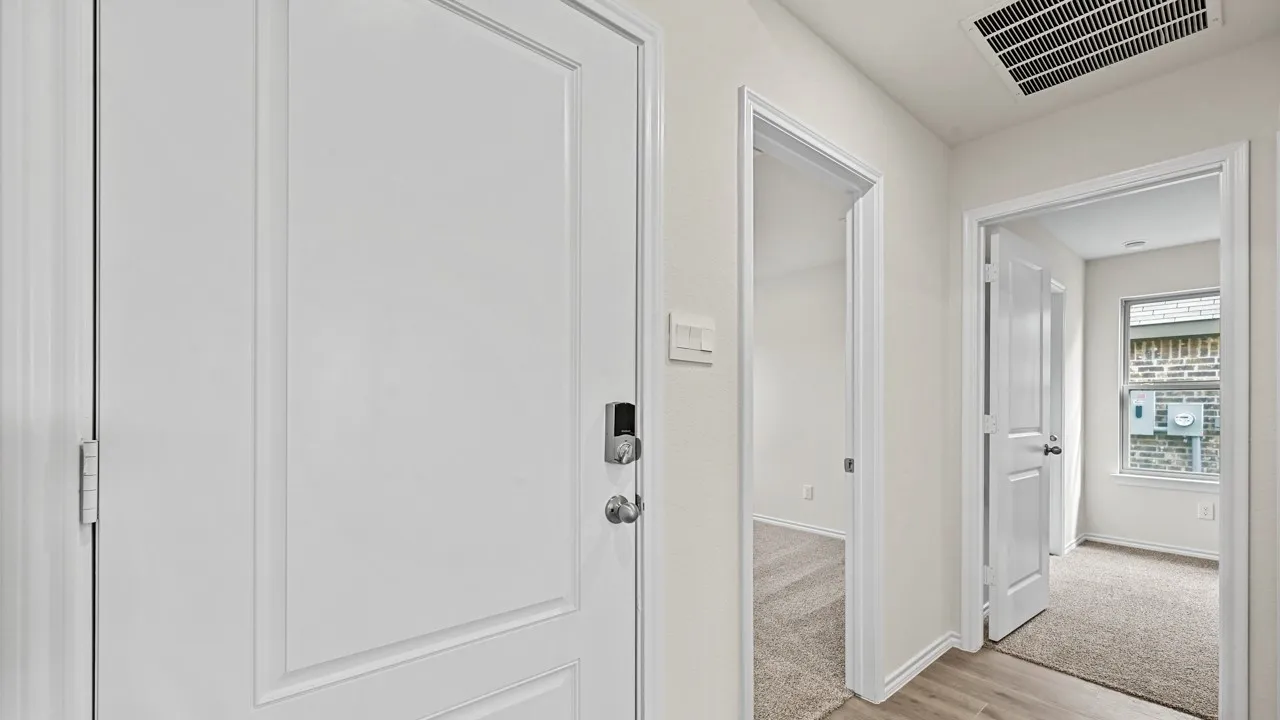 Hallway featuring light wood-finish flooring, white walls, white trim, and white panel doors