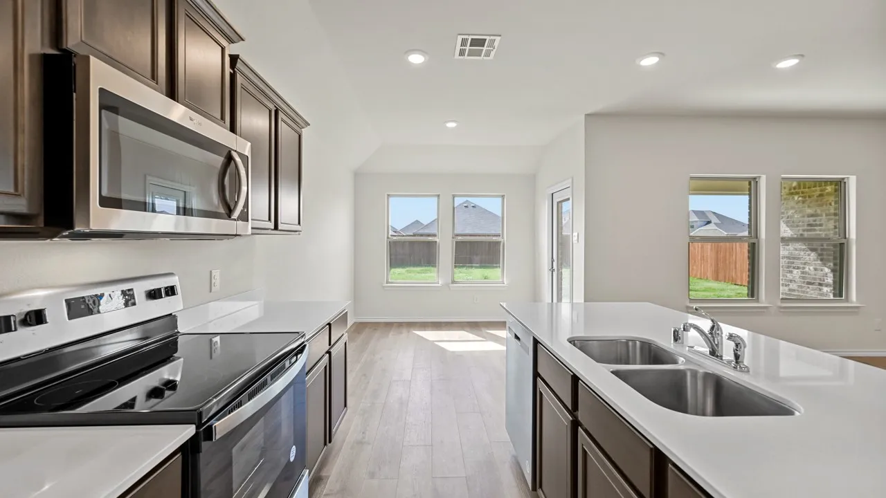 Kitchen featuring dark wood-finish cabinetry, stainless steel appliances, white countertops, and wood-finish flooring
