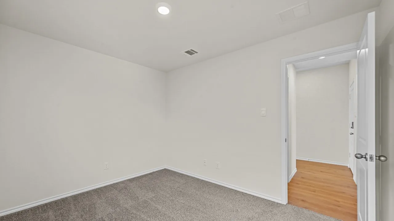 Recessed ceiling lighting, textured neutral walls, and plush carpet flooring