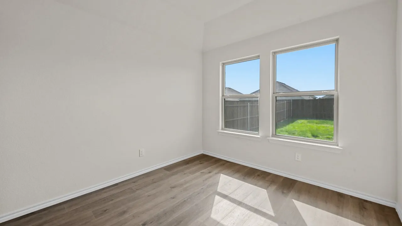 Neutral wall paint, wood-finish flooring, and two large windows
