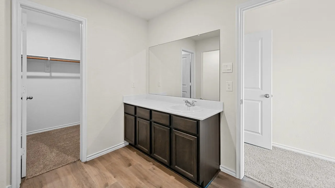 Vanity with a single basin sink, integrated countertop, and storage cabinetry