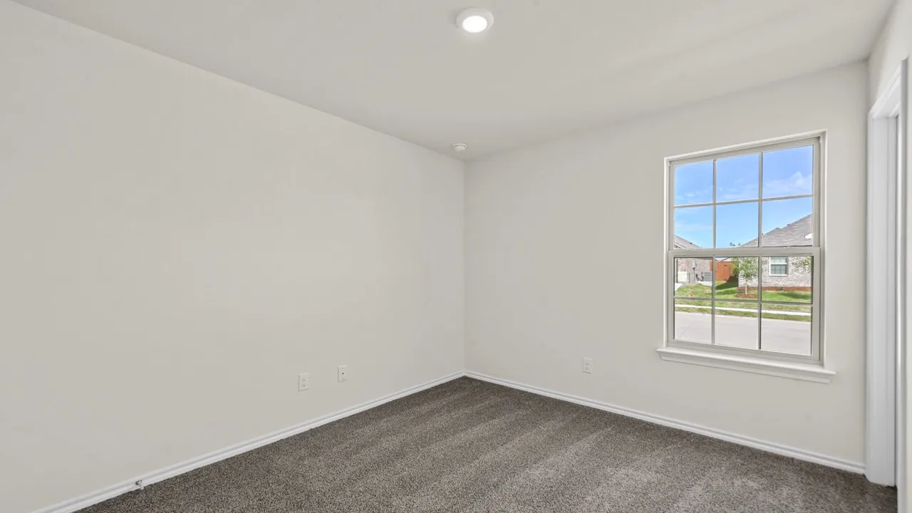 Neutral wall paint, gray carpet flooring, recessed ceiling lighting, and a multi-pane window