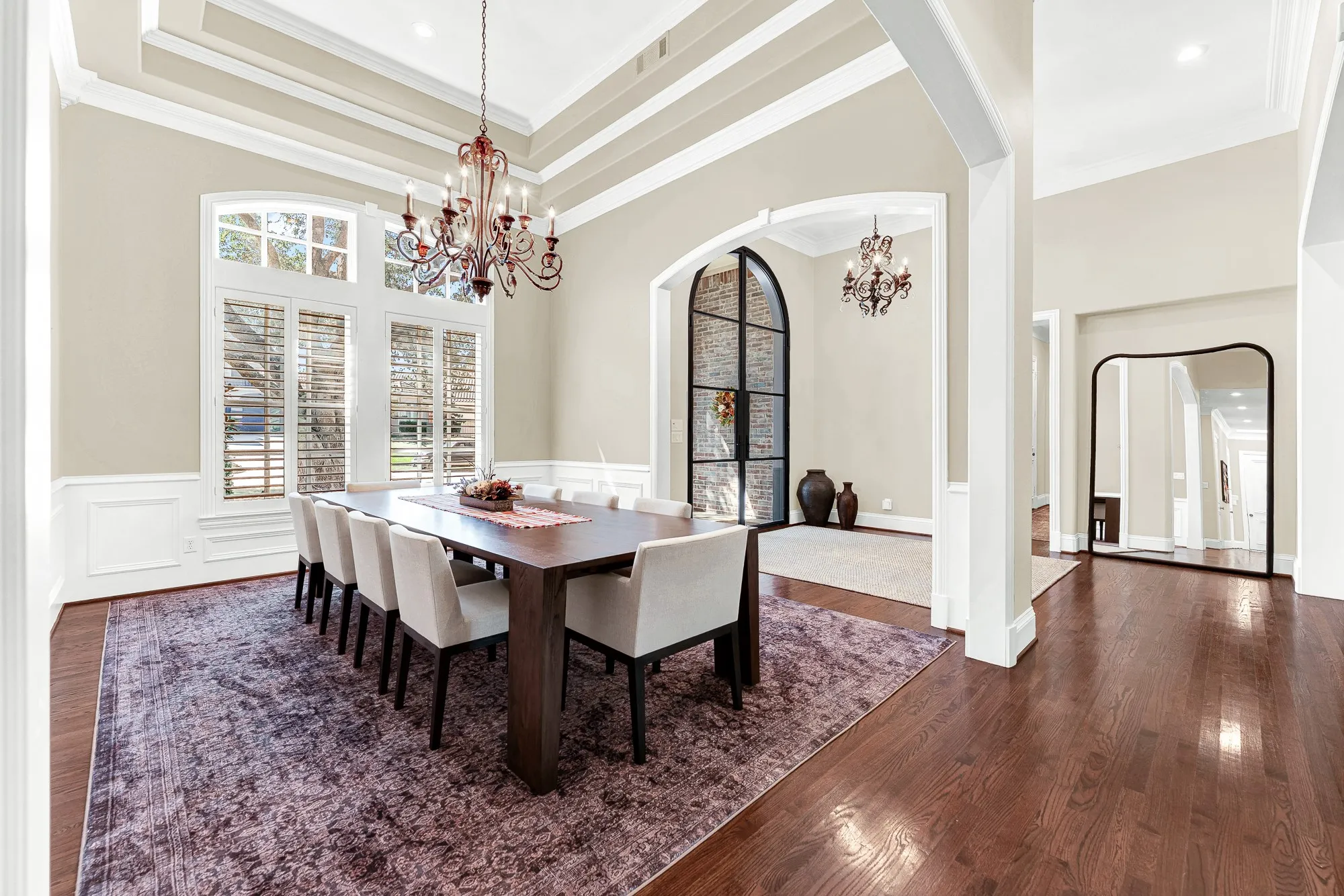 Tall transomed windows let gentle daylight dance across the classic white wall paneling. Visualize lingering over dessert with loved ones as dusk settles outside.