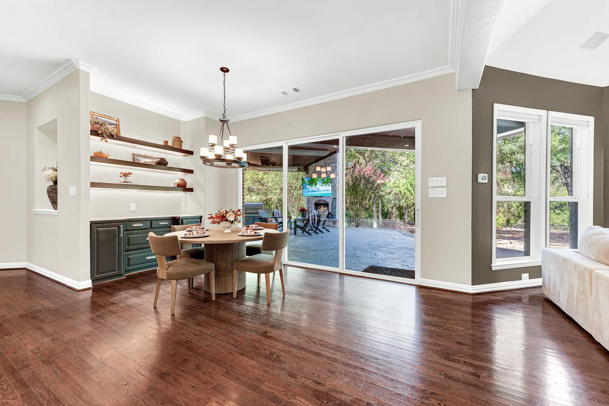 Expansive glass sliders create a fluid transition directly to the covered patio, flooding the room with natural light. You can easily share casual weekday breakfasts while taking in views of the lush backyard greenery.