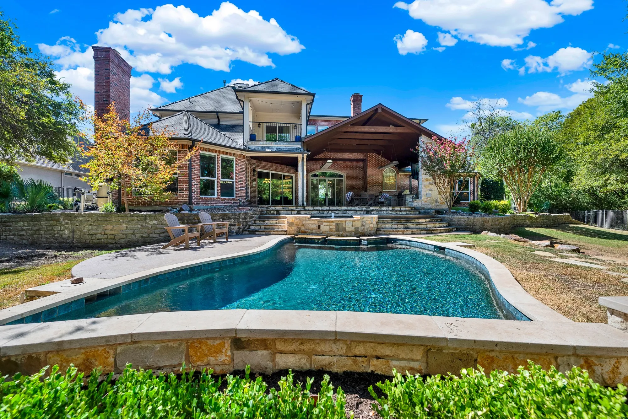 A covered outdoor living structure overlooks the brilliant turquoise pool waters. Host unforgettable weekend barbecues where friends relax poolside late into the warm evening.
