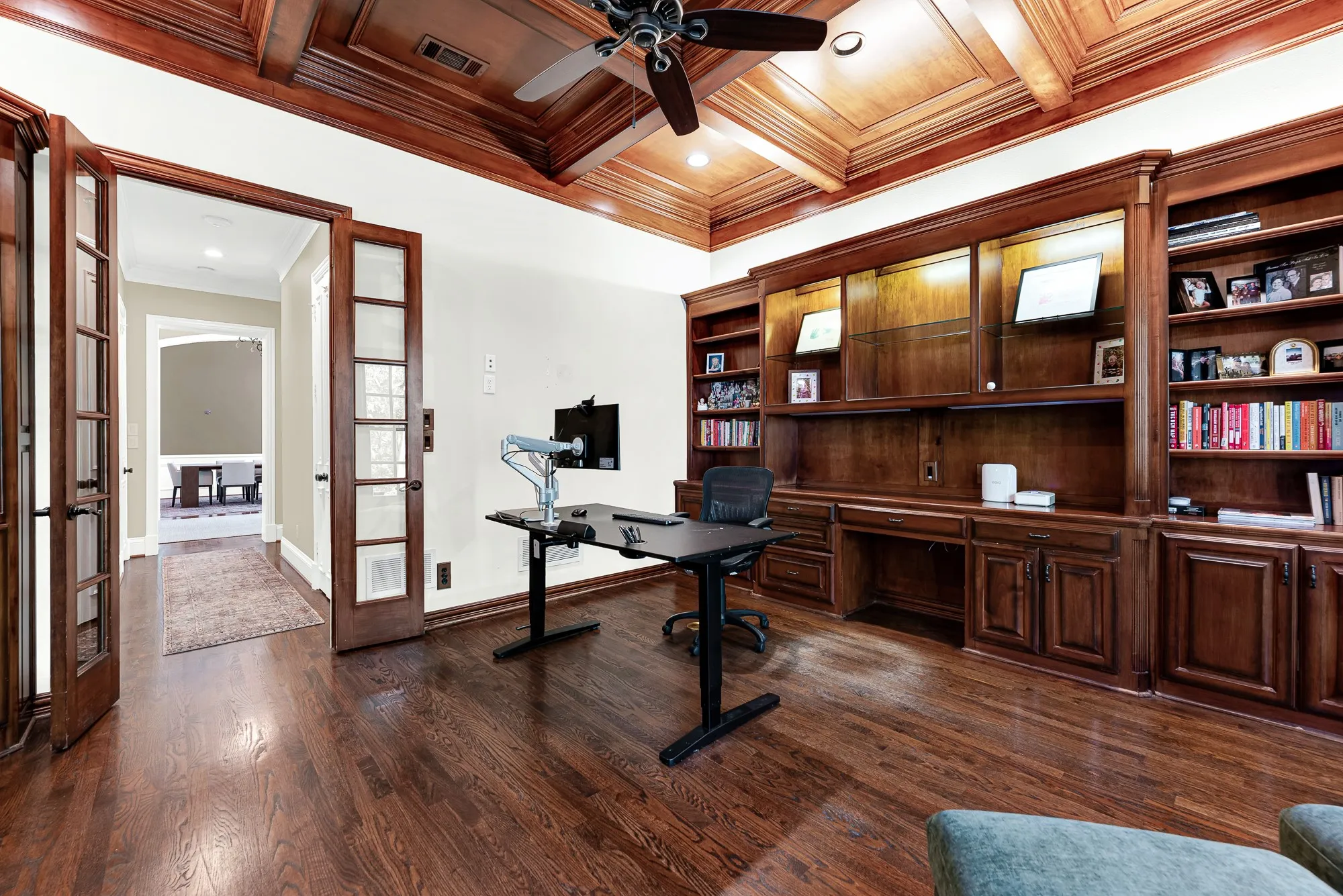 Warm illuminated built-ins and glass French doors create a cozy, defined study sanctuary. Settle into an inspiring afternoon, completely focused in your quiet private retreat